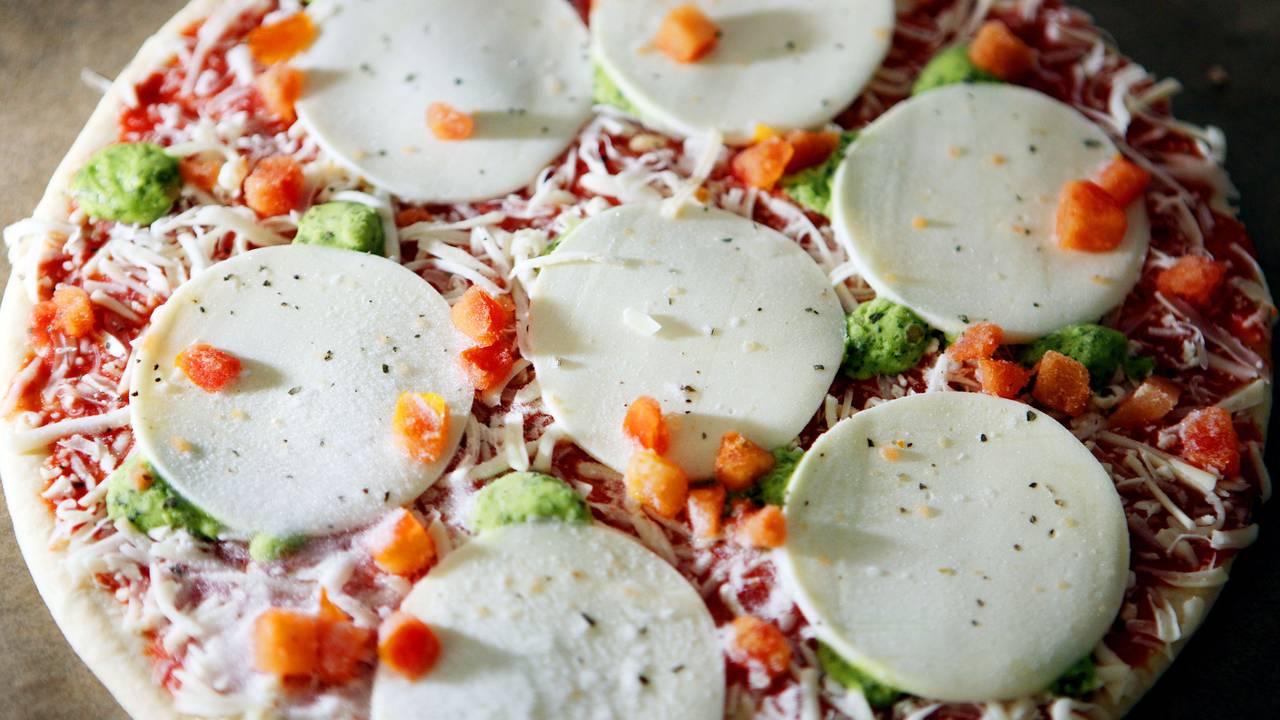 Eine Tiefkühlpizza liegt auf einem Backblech (Symbolfoto).
