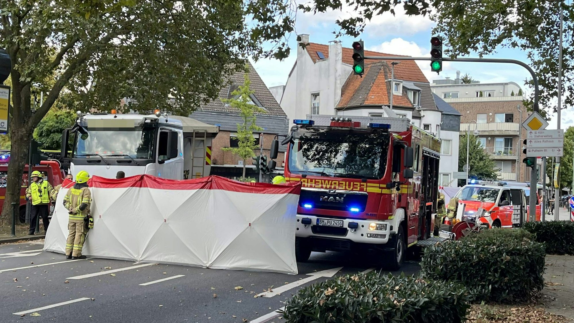 Einsatzfahrzeuge von Feuerwehr und Rettungsdienst stehen auf der Straße, quer über die Fahrbahn wurde ein Sichtschutz aufgestellt.