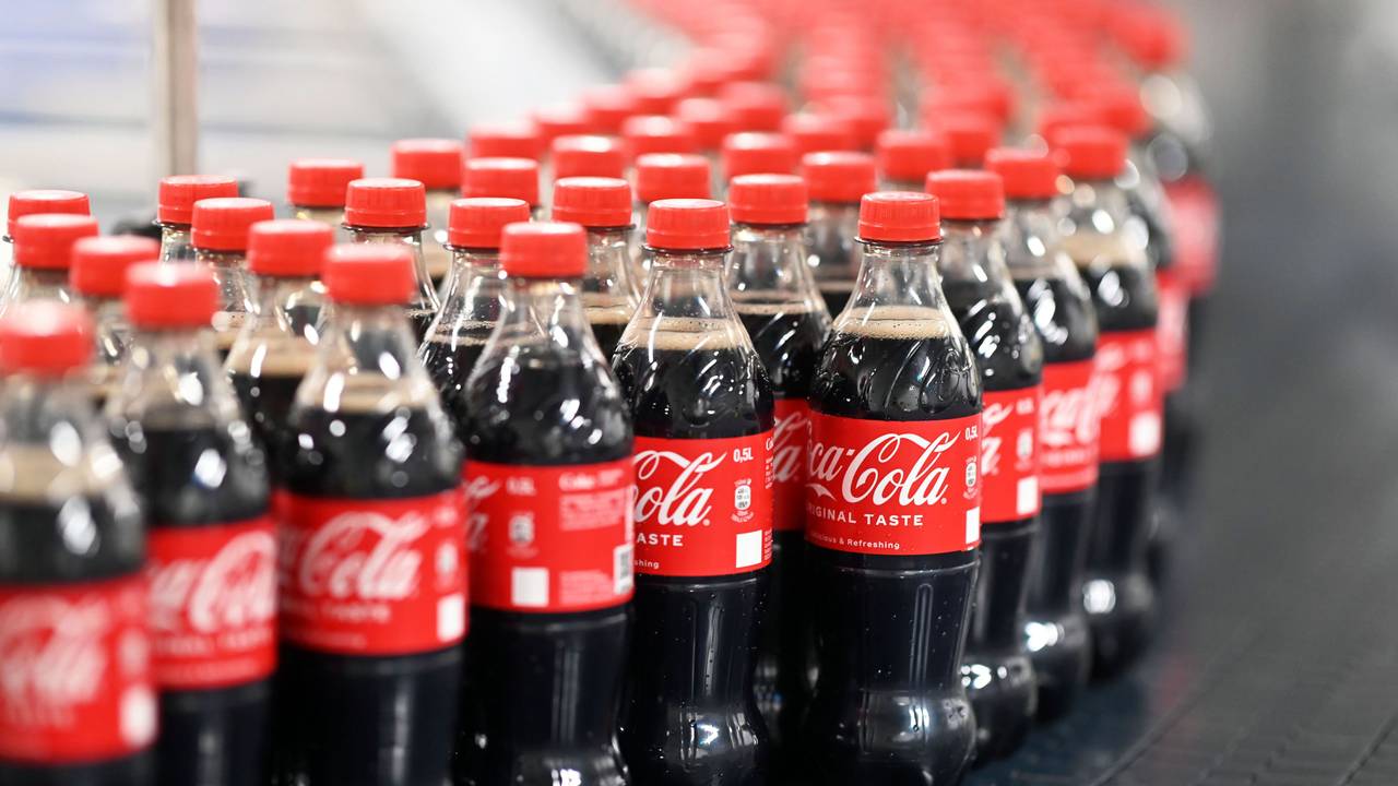 Abgefüllte 0,5 Liter Einweg Coca-Cola Flaschen werden über ein Förderband transportiert.