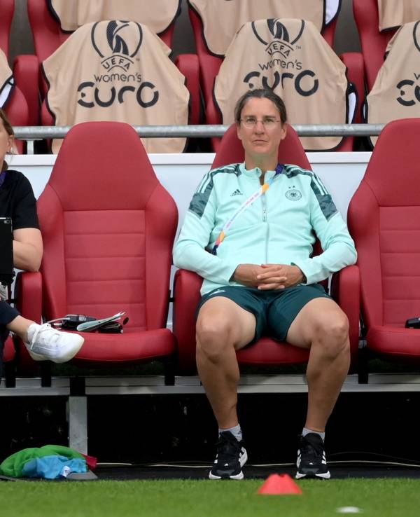 Bundestrainerin Martina Voss-Tecklenburg sitzt bei einem EM-Spiel neben ihrer Co-Trainerin Britta Carlson und Teampsychologin Birgit Prinz.
