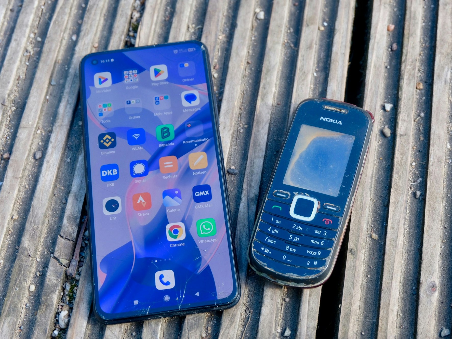 Manuel Skorzenskis modernes Smartphone liegt neben seinem alten Nokia-Handy auf dem Boden.