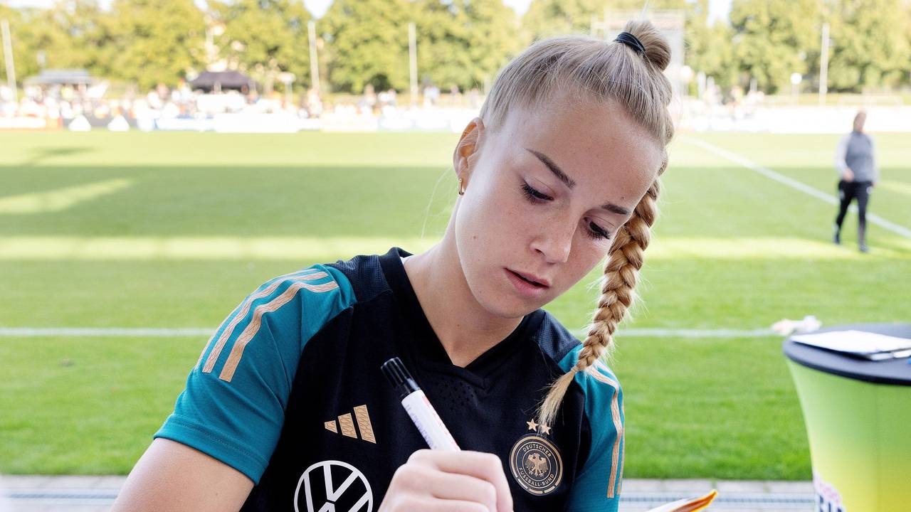 Giulia Gwinn schreibt am Rande des DFB-Trainings Autogramme.