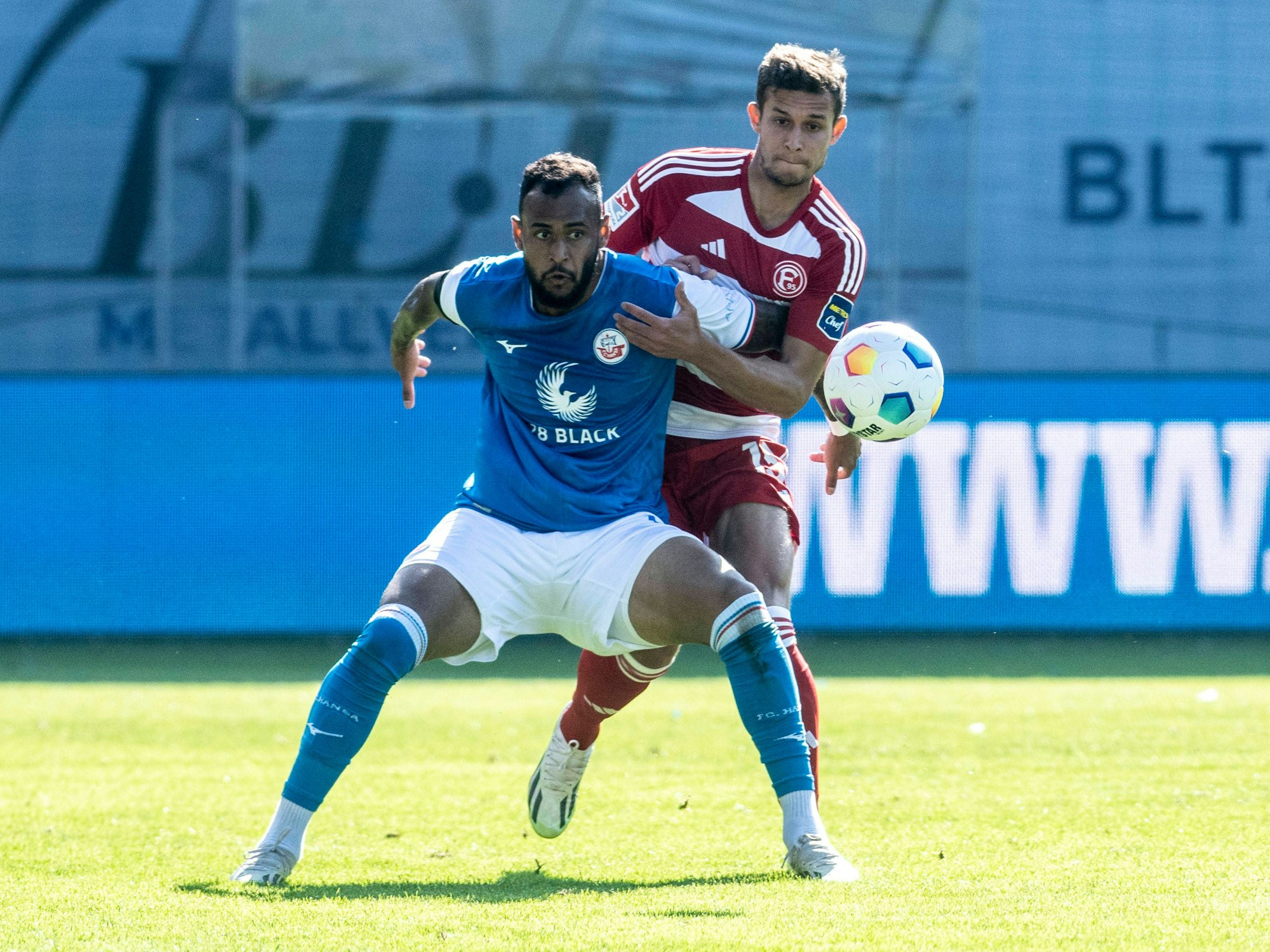 Fortuna Düsseldorfs Tim Oberdorf im Zweikampf mit Hansa Rostocks Júnior Brumado.