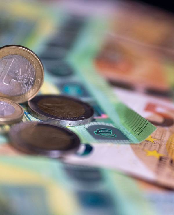 Geldscheine mit dem Wert von 100 und 50 Euro und Münzen liegen auf einem Tisch.