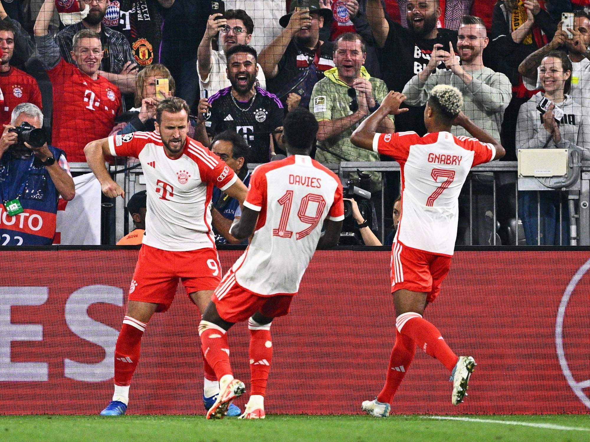 Allianz-Arena, Bayerns Harry Kane jubelt mit Alphonso Davies und Serge Gnabry.