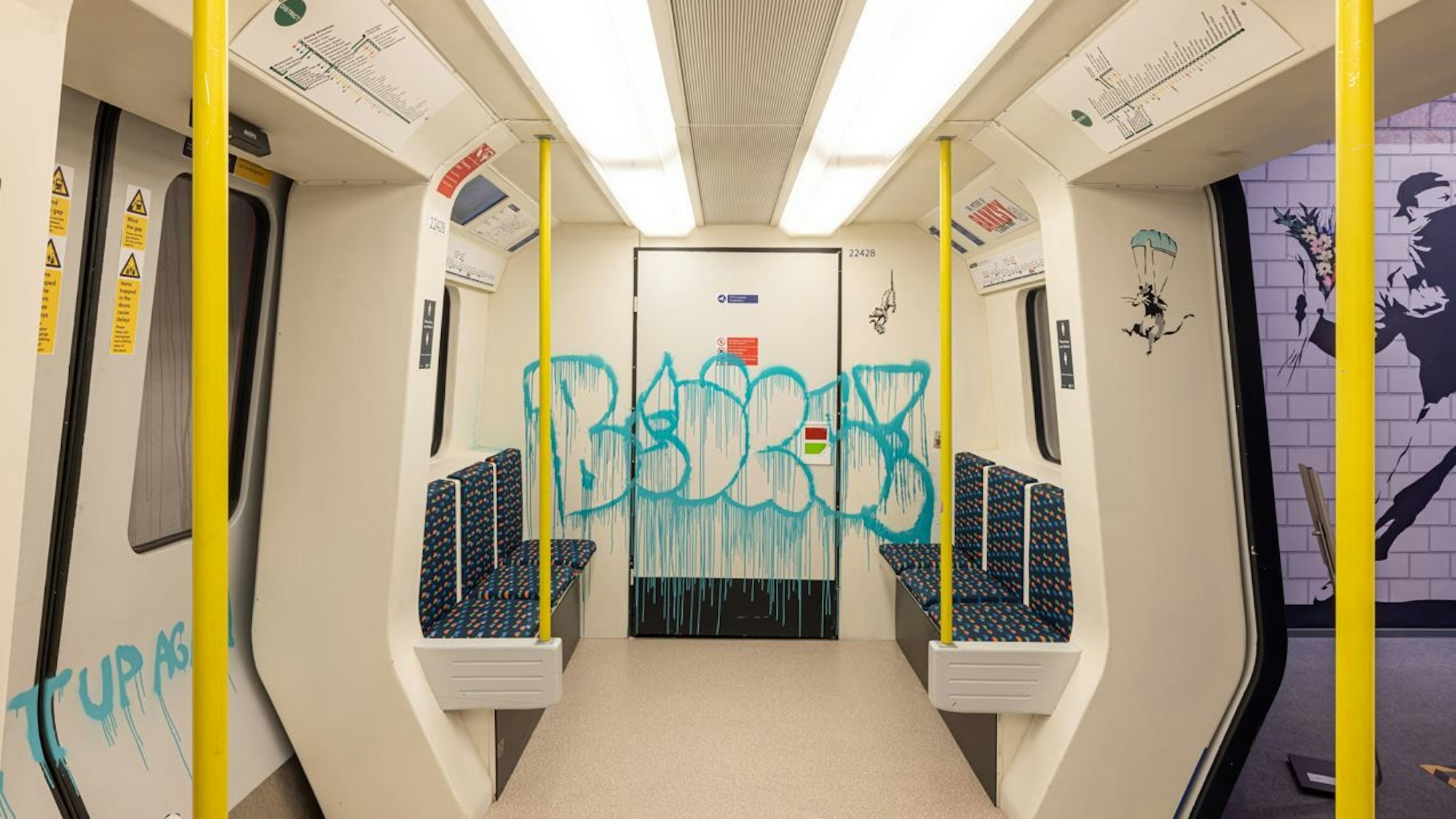 Blick in eine leere, beschmierte S-Bahn, die als Teil einer Ausstellung in einem Innenraum steht.