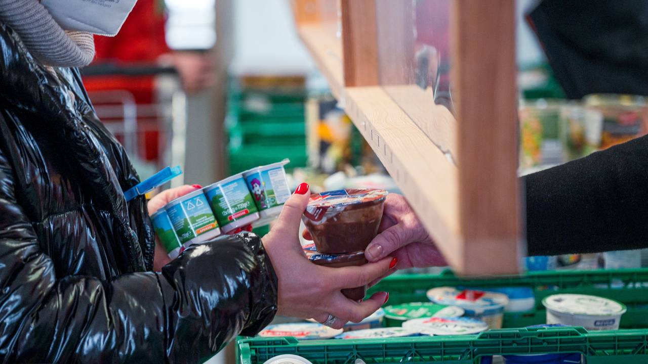 Eine Kundin kauft Joghurt und Pudding ein.