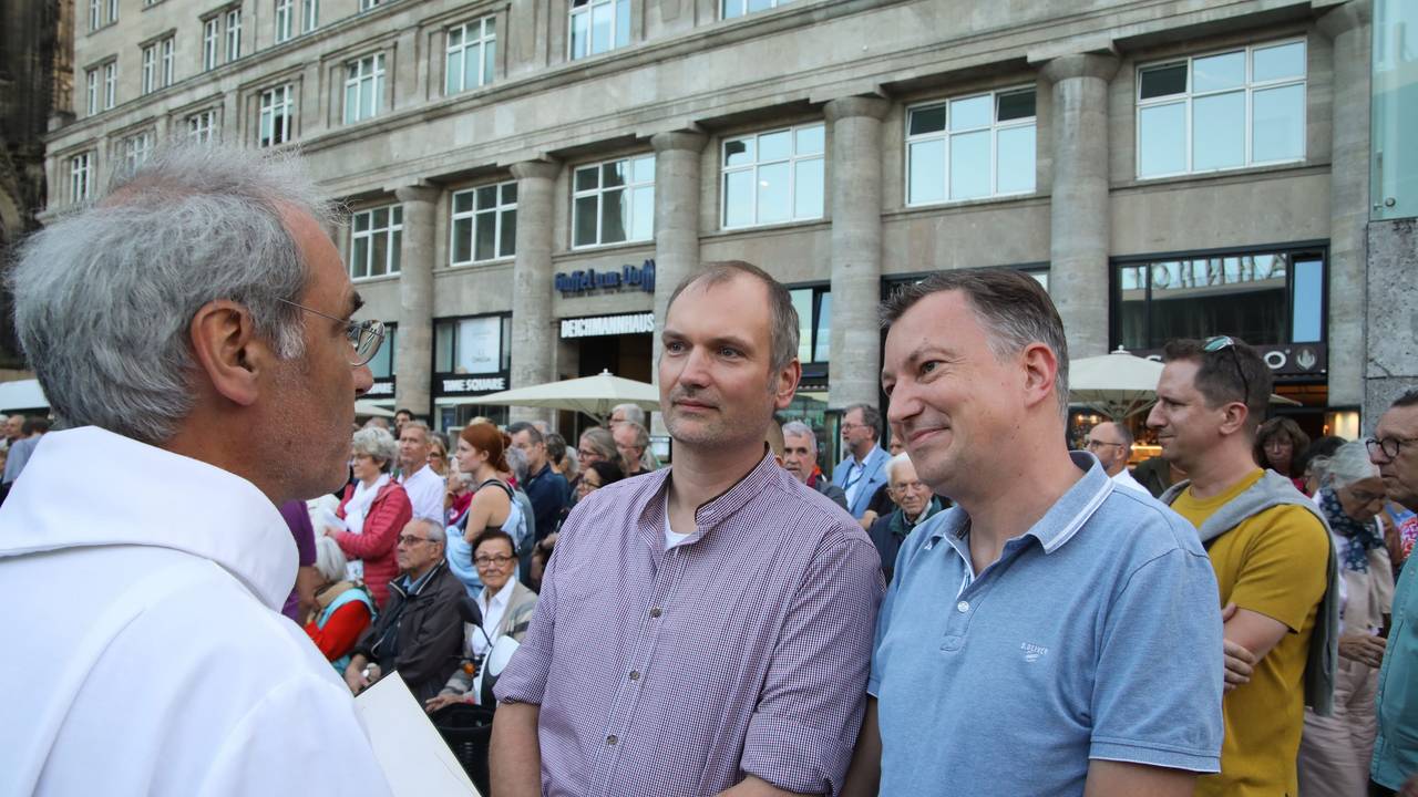 Klaus Schulze Herderling (l) und Peter Bispeling lassen sich am 20. September 2023) beim Gottesdienst in Köln von einem Pfarrer segnen.