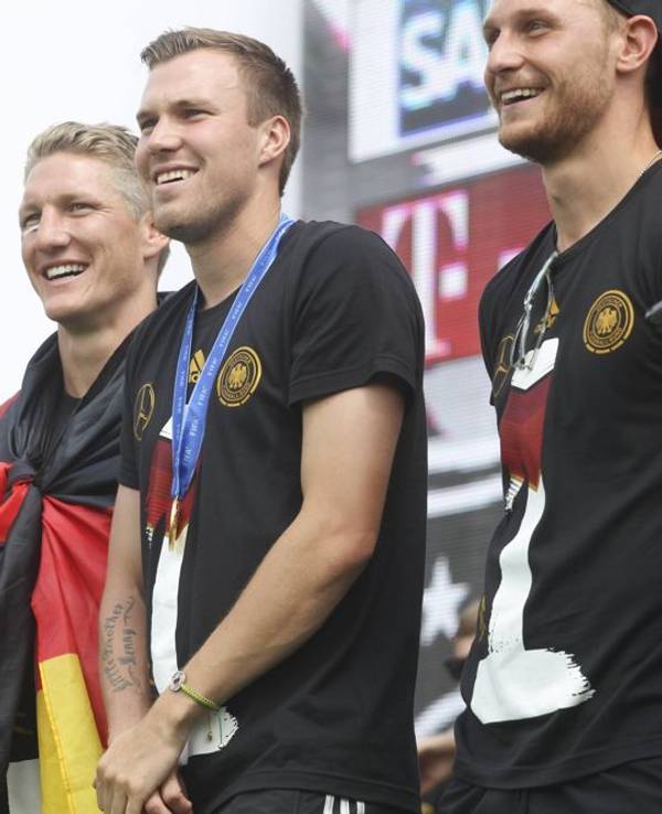Manuel Neuer, Bastian Schweinsteiger, Kevin Großkreutz und Shkodran Mustafi: Die deutsche Nationalmannschaft feiert den WM-Sieg auf der Fanmeile vor dem Brandenburger Tor.