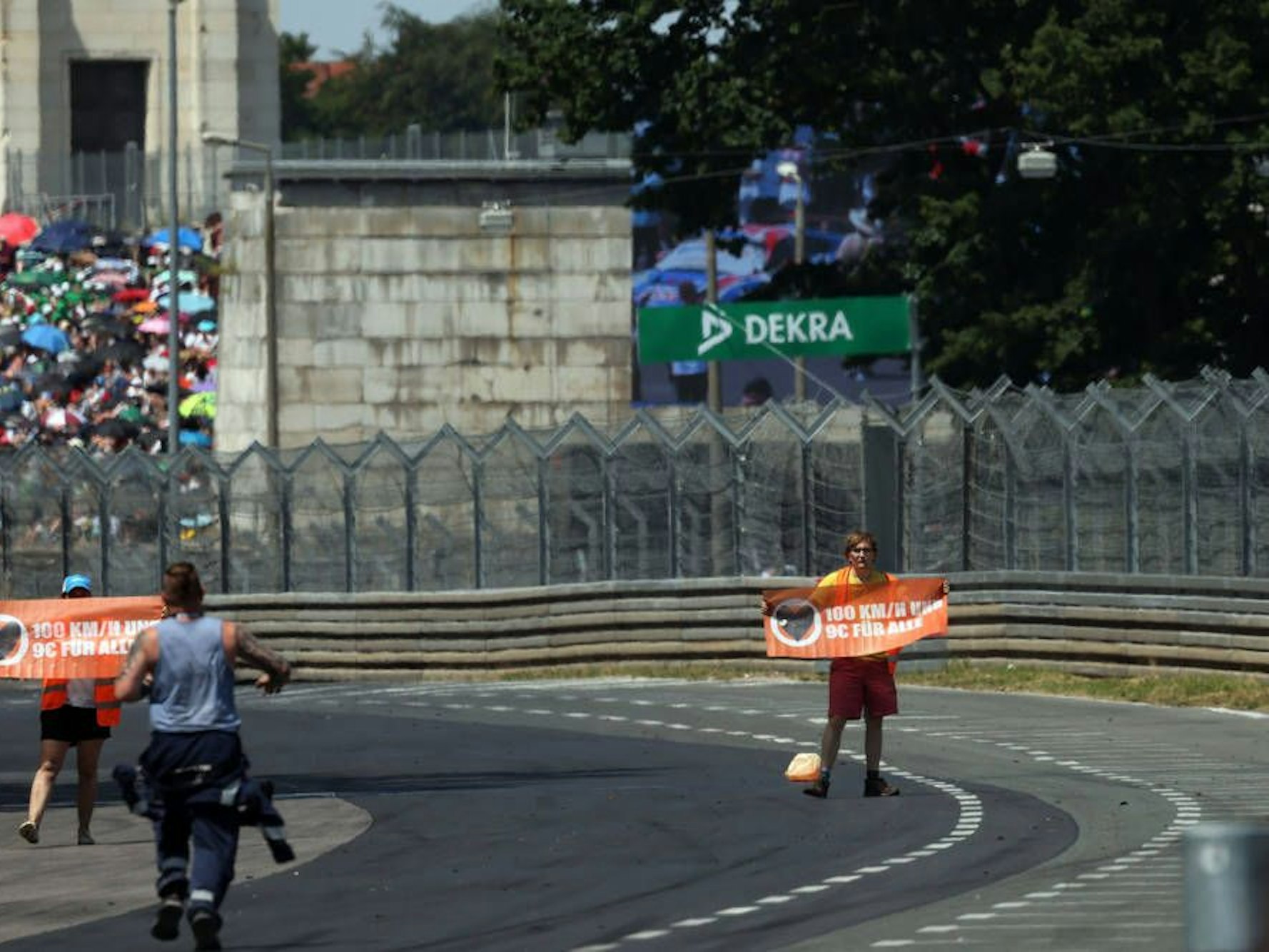 Klimaaktivisten stehen am Ende der Start-Zielgeraden auf der Rennstrecke.