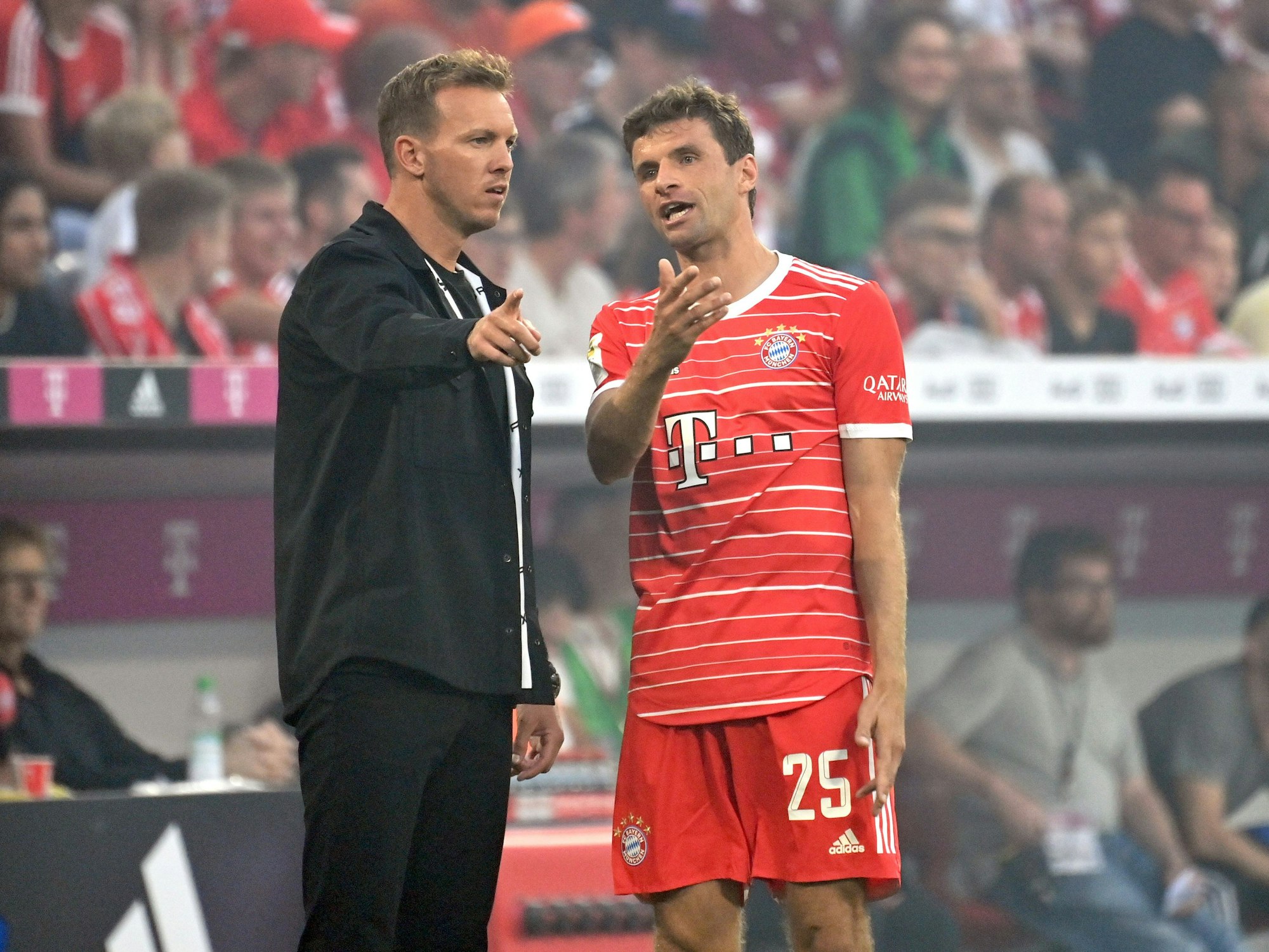 Trainer Julian Nagelsmann diskutiert mit Thomas Müller am Spielfeldrand.