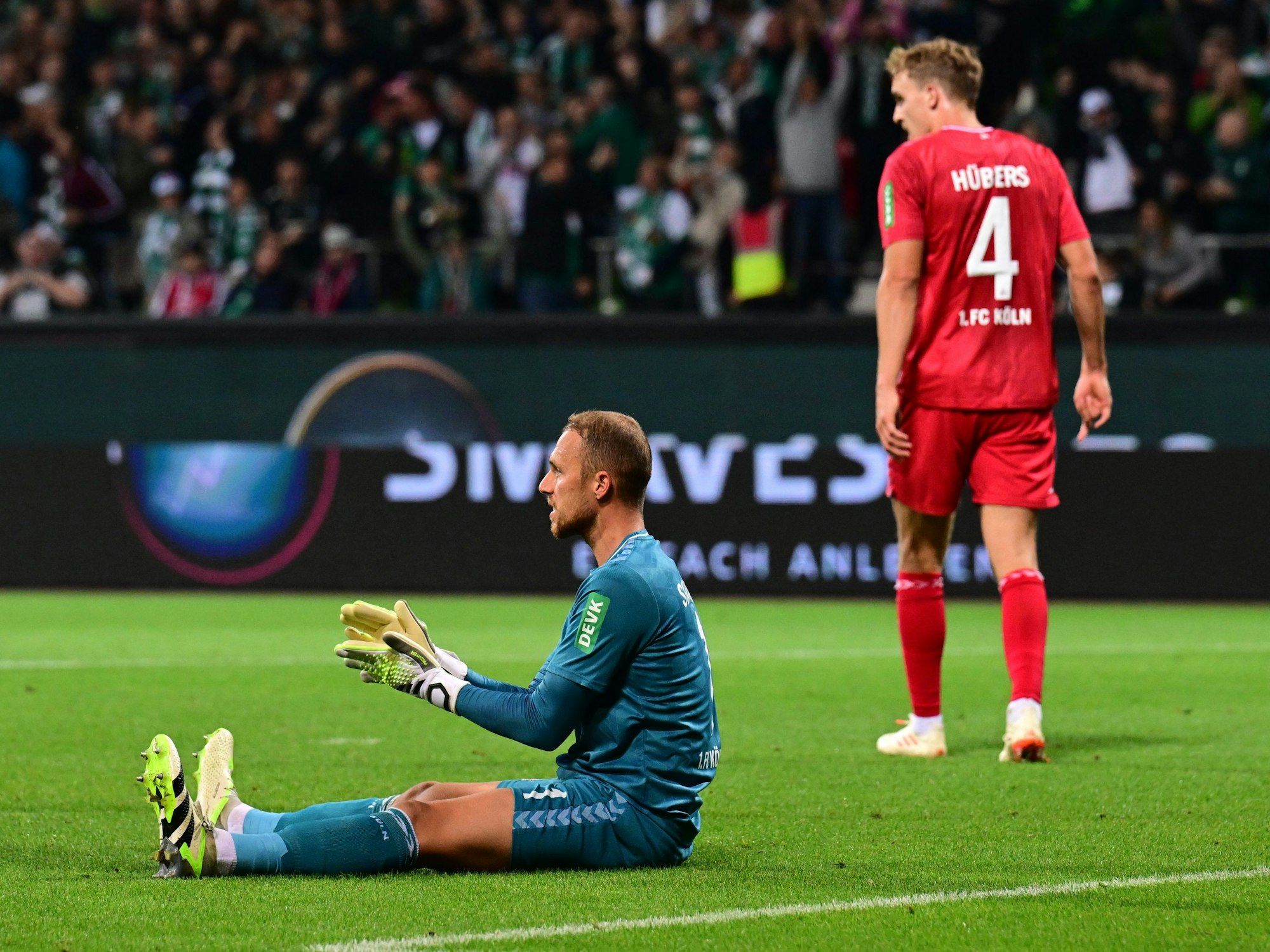 Marvin Schwäbe sitzt nach dem Tor zum 1:2 gegen Werder Bremen enttäuscht auf dem Boden.