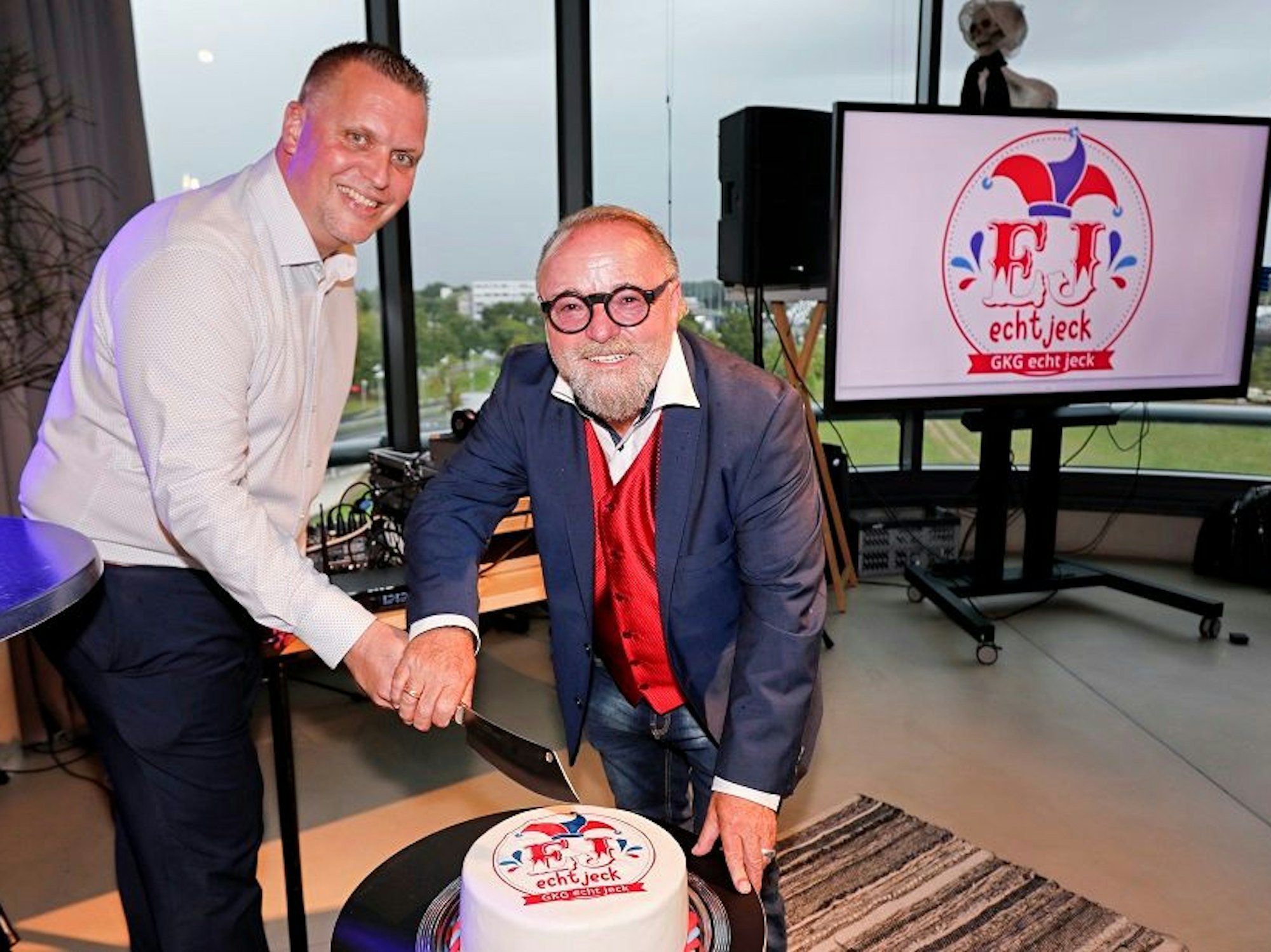 Rolf B. Pieper und Alex Sälzer (l.) schneiden gemeinsam eine Torte an.