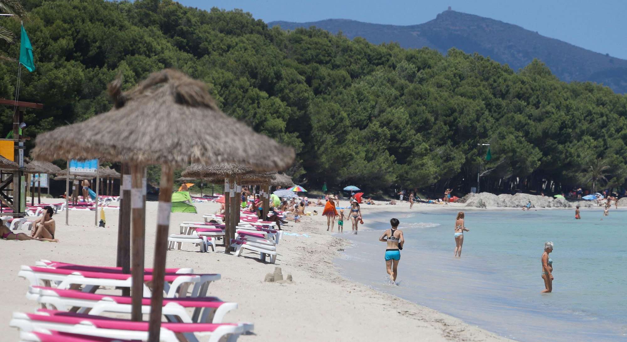 Menschen baden im Meer am Strand de Muro im Norden von Mallorca.