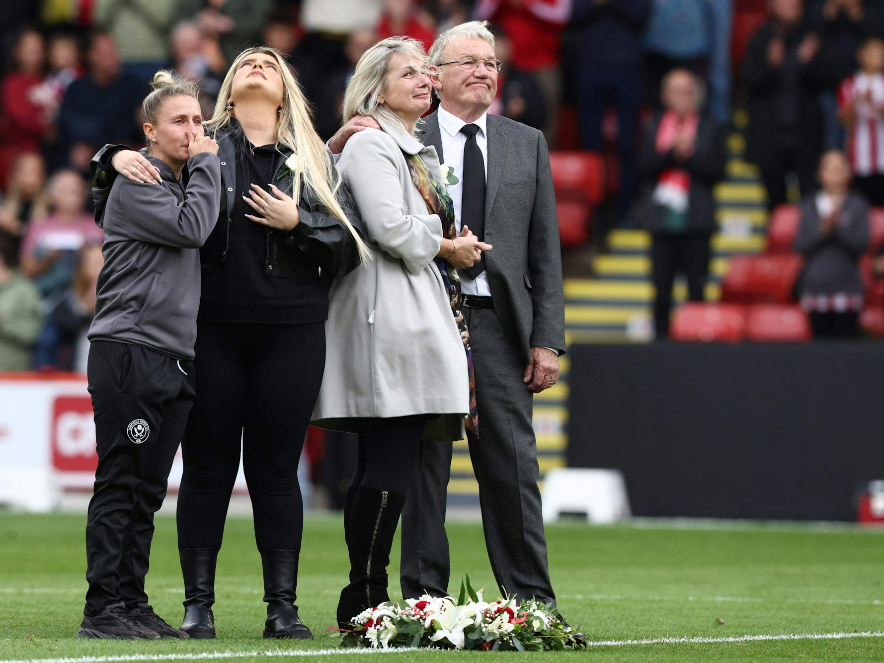 Sheffield-Kapitänin Sophie Barker, Maddy Cusacks Schwester und Mutter sowie Klub-Legende Tony Currie waren vor dem Spiel der Männer bei einer Schweigeminute tief bewegt.