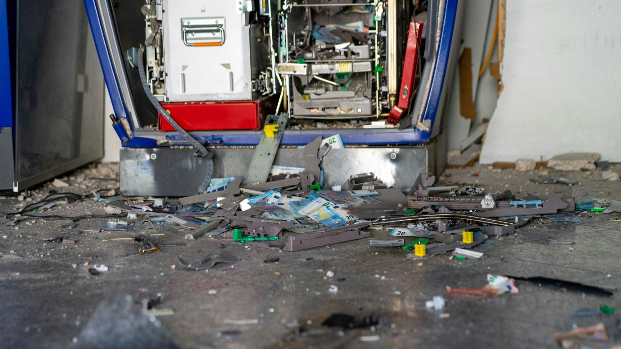 Trümmer und Geldscheine liegen verstreut auf dem Boden einer Bankfiliale