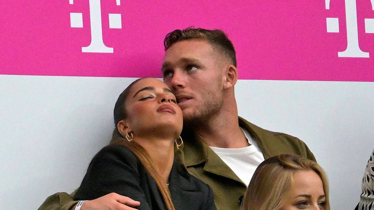 Bayern Münchens Daniel Peretz hat seine Freundin Noa Kirel im Arm. Sie sitzen auf der Tribüne der Allianz-Arena.