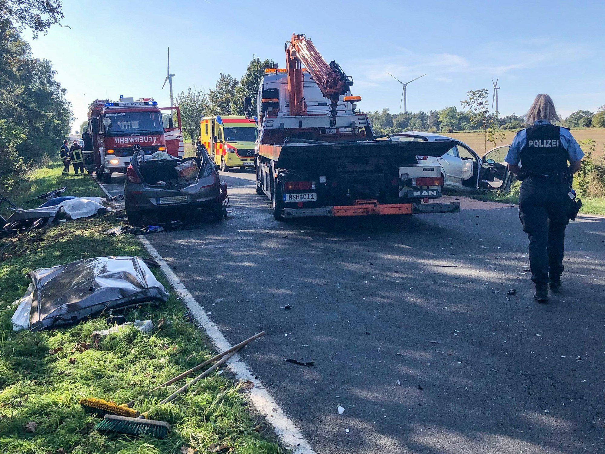 Eine Polizistin geht über die Unfallstelle auf der Landstraße L 151.