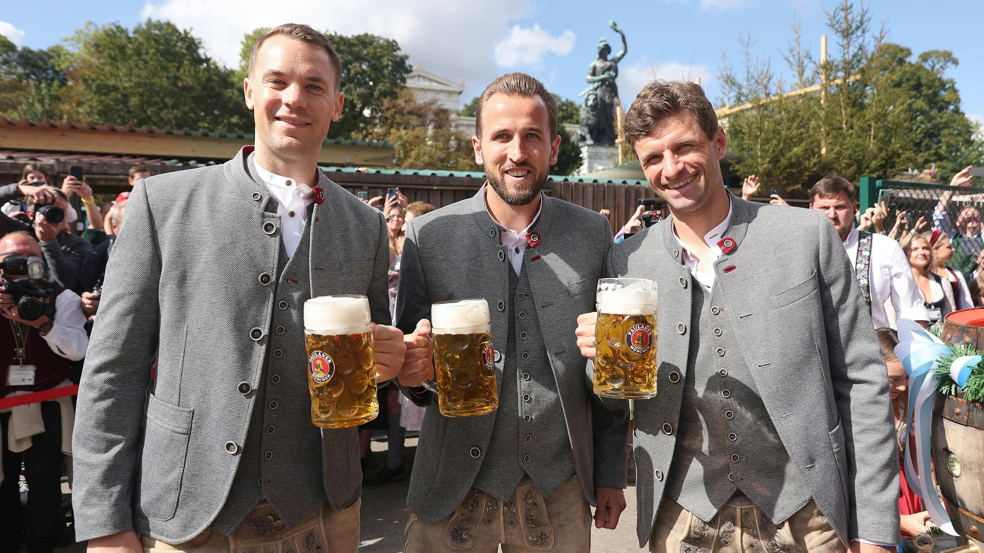 Manuel Neuer (l-r), Harry Kane und Thomas Müller vom FC Bayern München stehen mit einer Maß Bier vor dem Käferzelt.