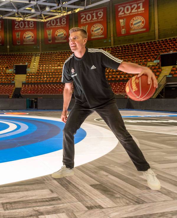Steffen Hamann spielt mit einem Basketball in München auf einem LED-Boden.