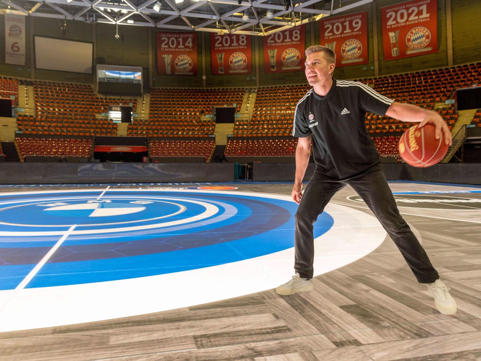 Steffen Hamann spielt mit einem Basketball in München auf einem LED-Boden.