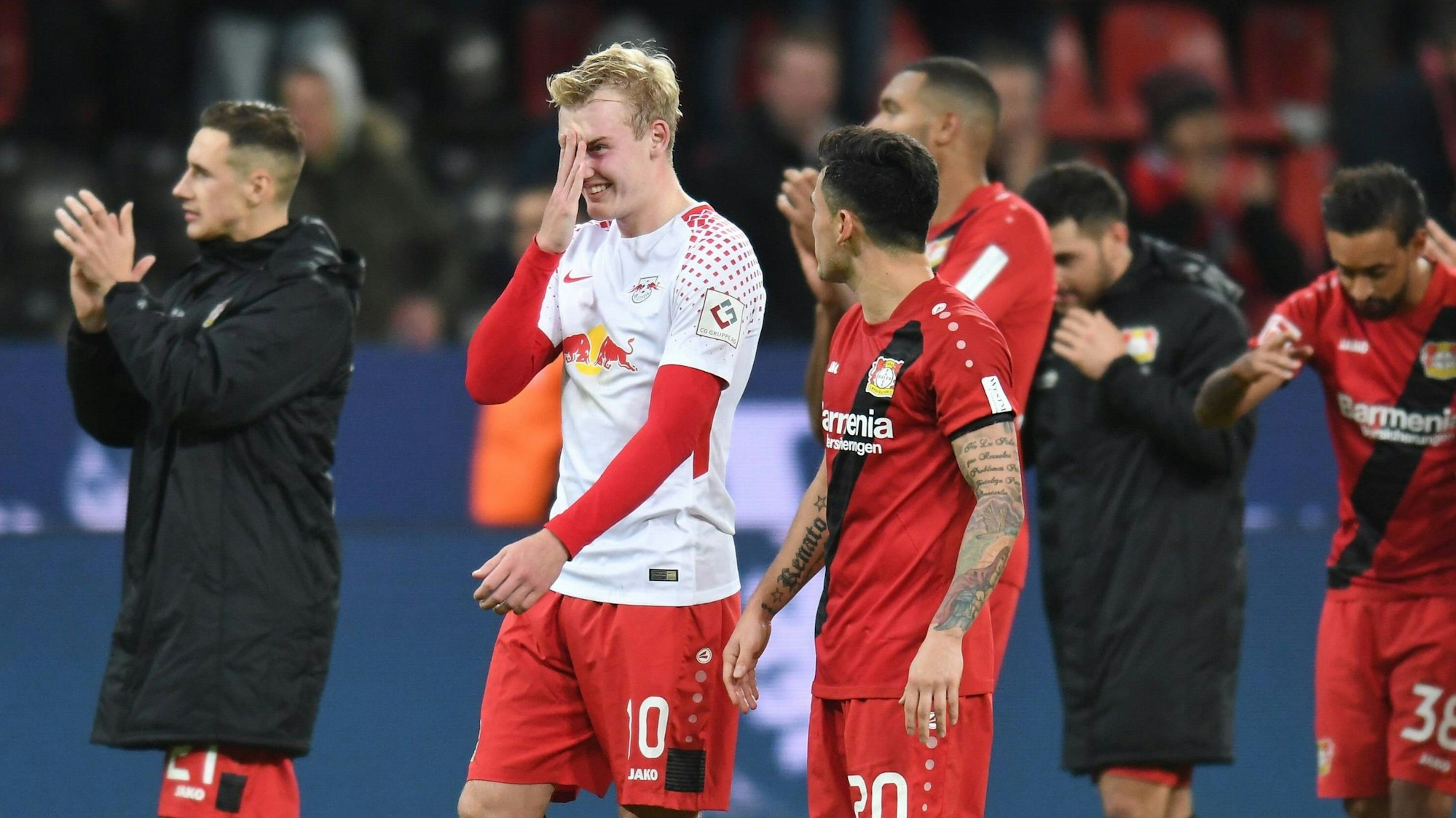 Julian Brandt hält sich nach einem Spiel von Bayer Leverkusen die Hand vors Gesicht.