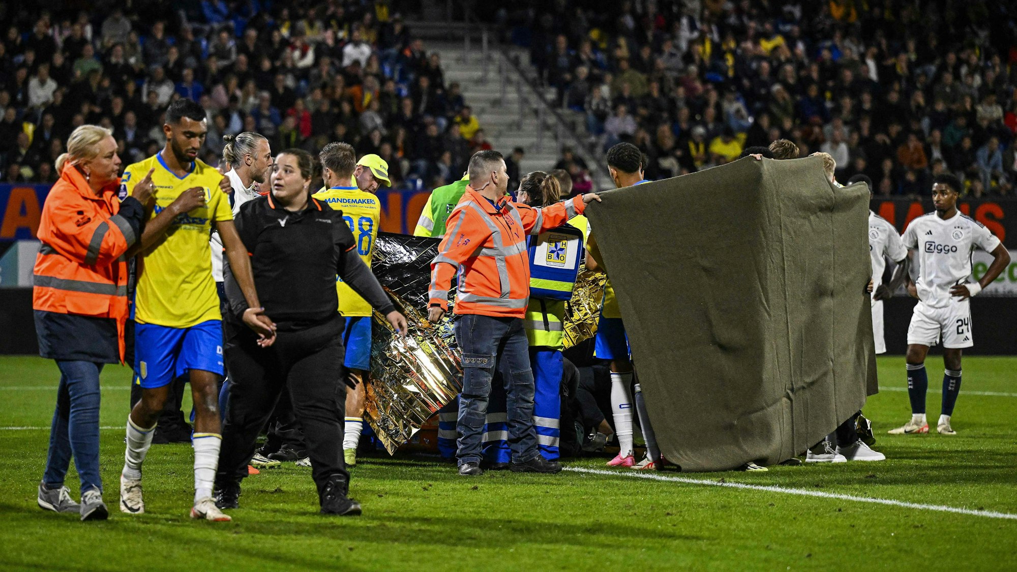 Torwart Etienne Vaessen wird nach seinem Zusammenbruch medizinisch versorgt. Ordner schirmen die Szene beim Spiel zwischen RKC Waalwijk und Ajax Amsterdam ab.
