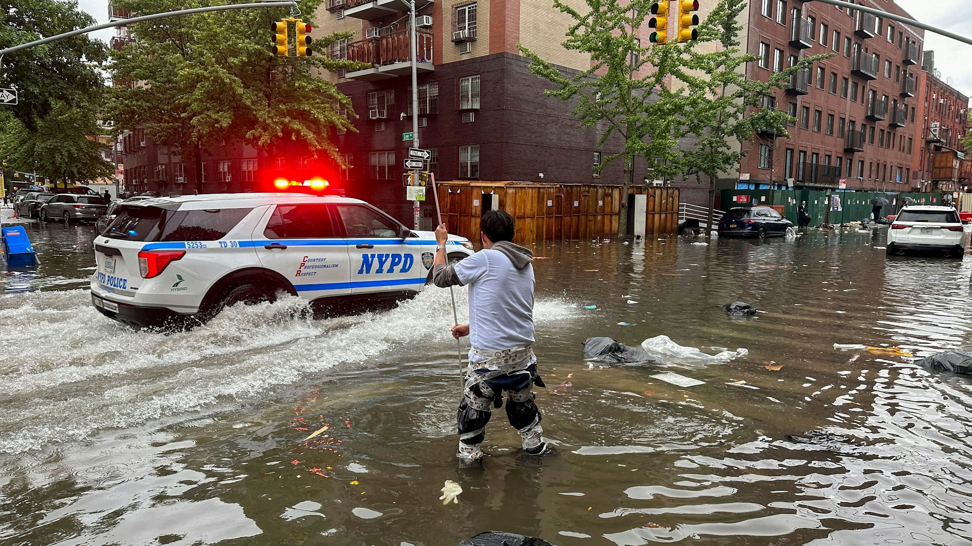 Ein Mann versucht im Stadtbezirk Brooklyn einen Abfluss im Hochwasser zu reinigen.
