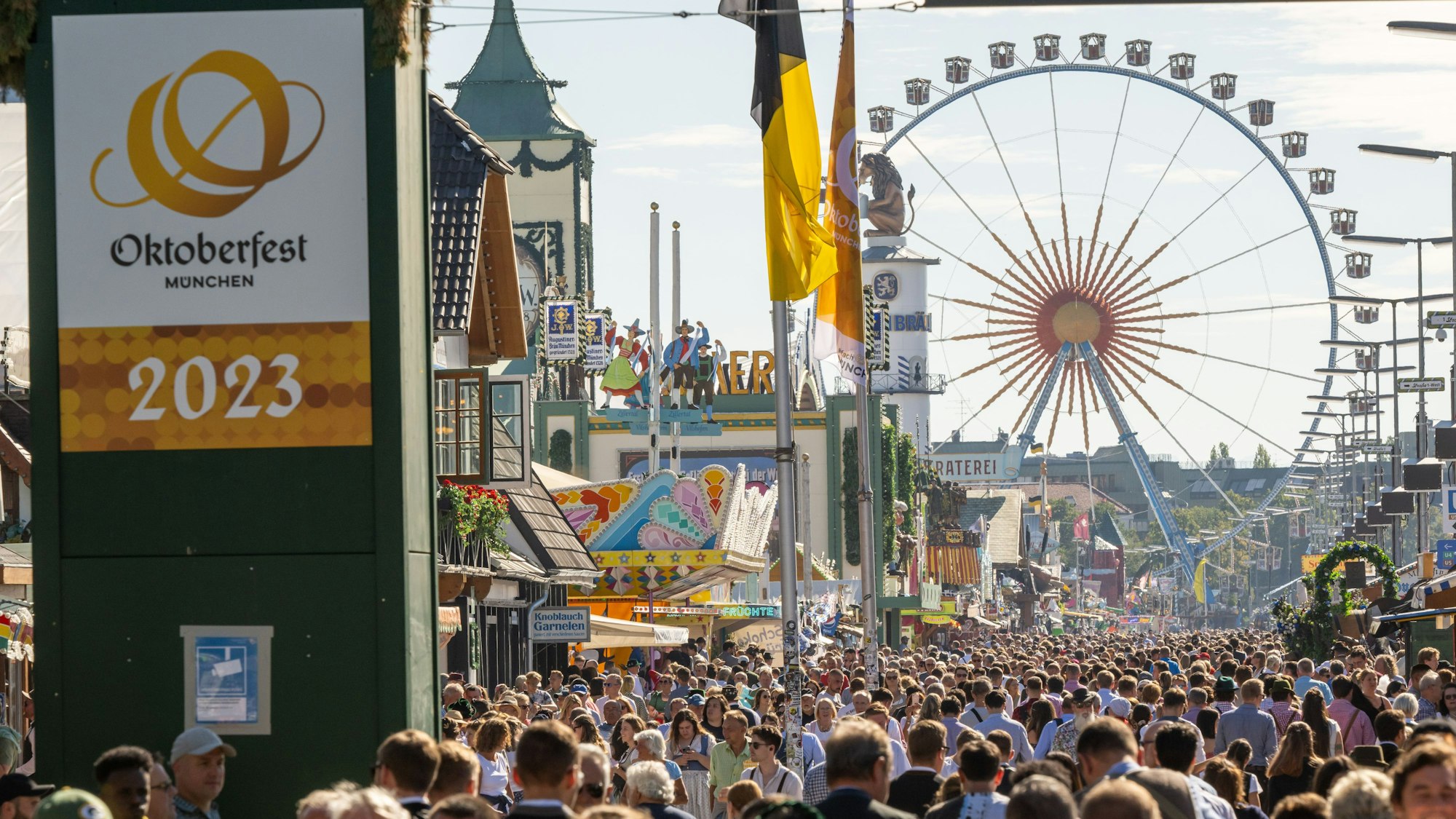 Wiesn-Besucherinnen und Besucher gehen beim 188. Münchner Oktoberfest über das Gelände.
