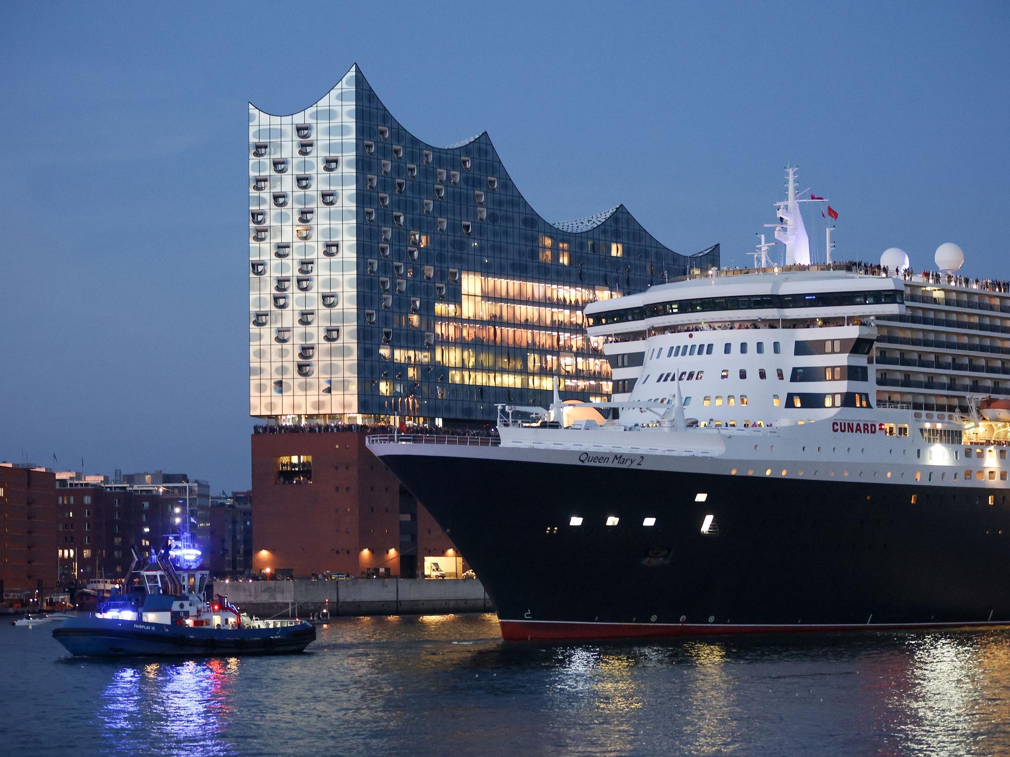 Das Kreuzfahrtschiff Queen Mary 2 fährt zum Auftakt der Cruise Days am Abend durch den Hamburger Hafen an der Elbphilharmonie entlang, hier im August 2022.