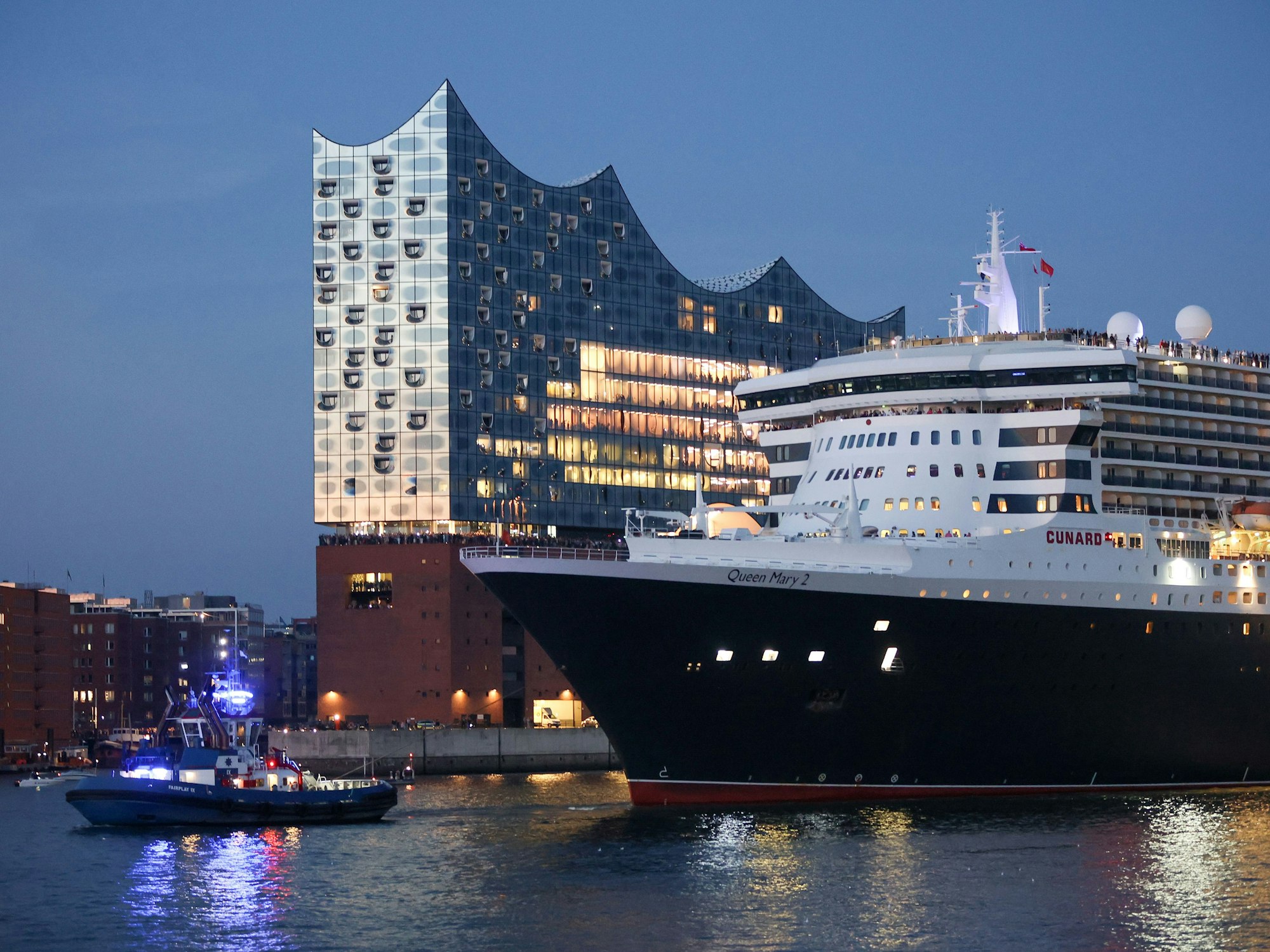 Das Kreuzfahrtschiff Queen Mary 2 fährt zum Auftakt der Cruise Days am Abend durch den Hamburger Hafen an der Elbphilharmonie entlang, hier im August 2022.