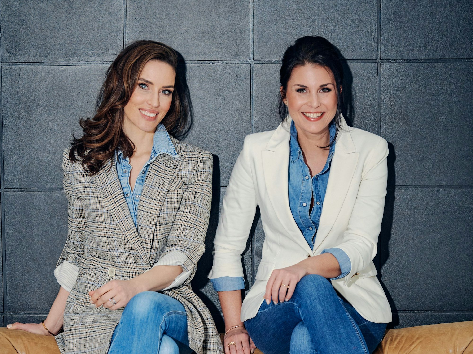 Anna Funck und Vanessa Blumhagen sitzen auf einer Couch.