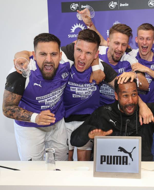 Die Spieler von Osnabrück feiern den Aufstieg in die 2. Bundesliga und überraschen ihren Trainer Daniel Thioune (M) bei der Pressekonferenz mit einer Bierdusche.