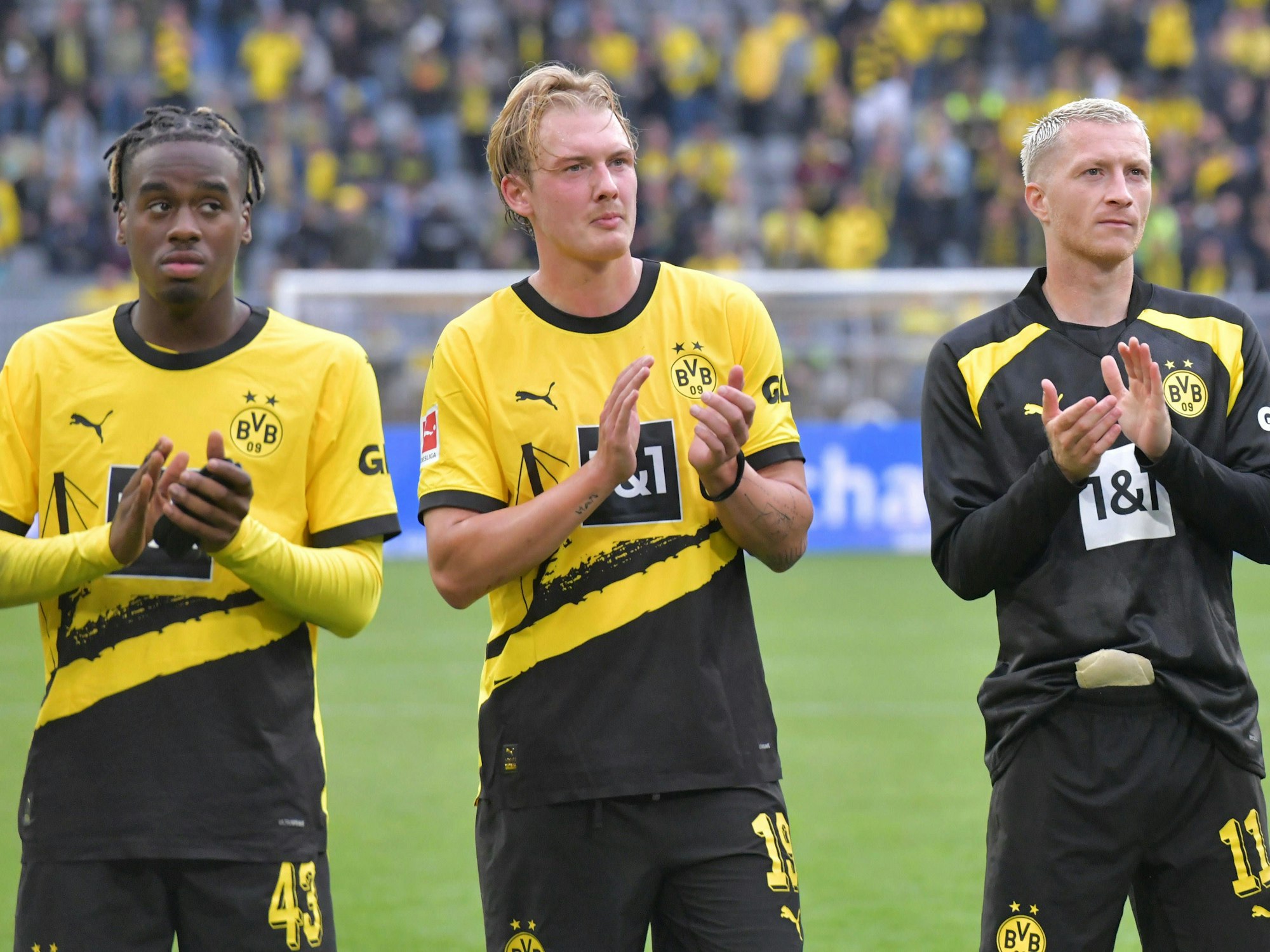 Borussia Dortmund: Jamie Bynoe-Gittens (li.), Julian Brandt und Marco Reus (re.) klatschen.