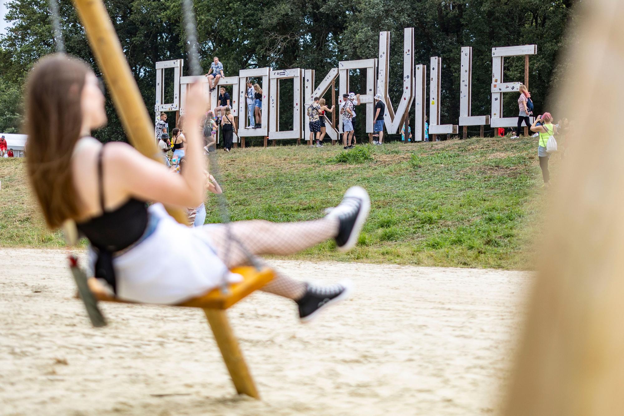 Eine junge Frau schaukelt vor dem Schriftzug Parookaville, der von den Besuchern als Foto-Hotspot genutzt wird.