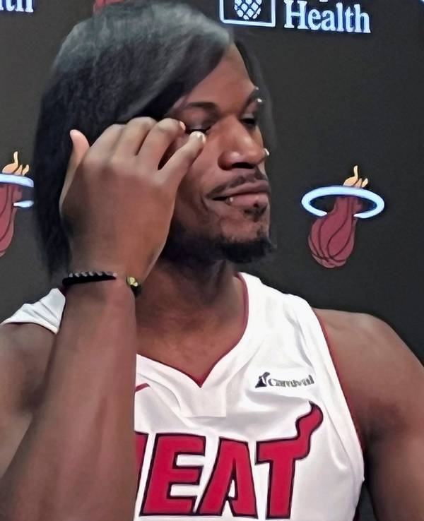 NBA-Star Jimmy Butler fährt sich bei einer Pressekonferenz durch die Haare.
