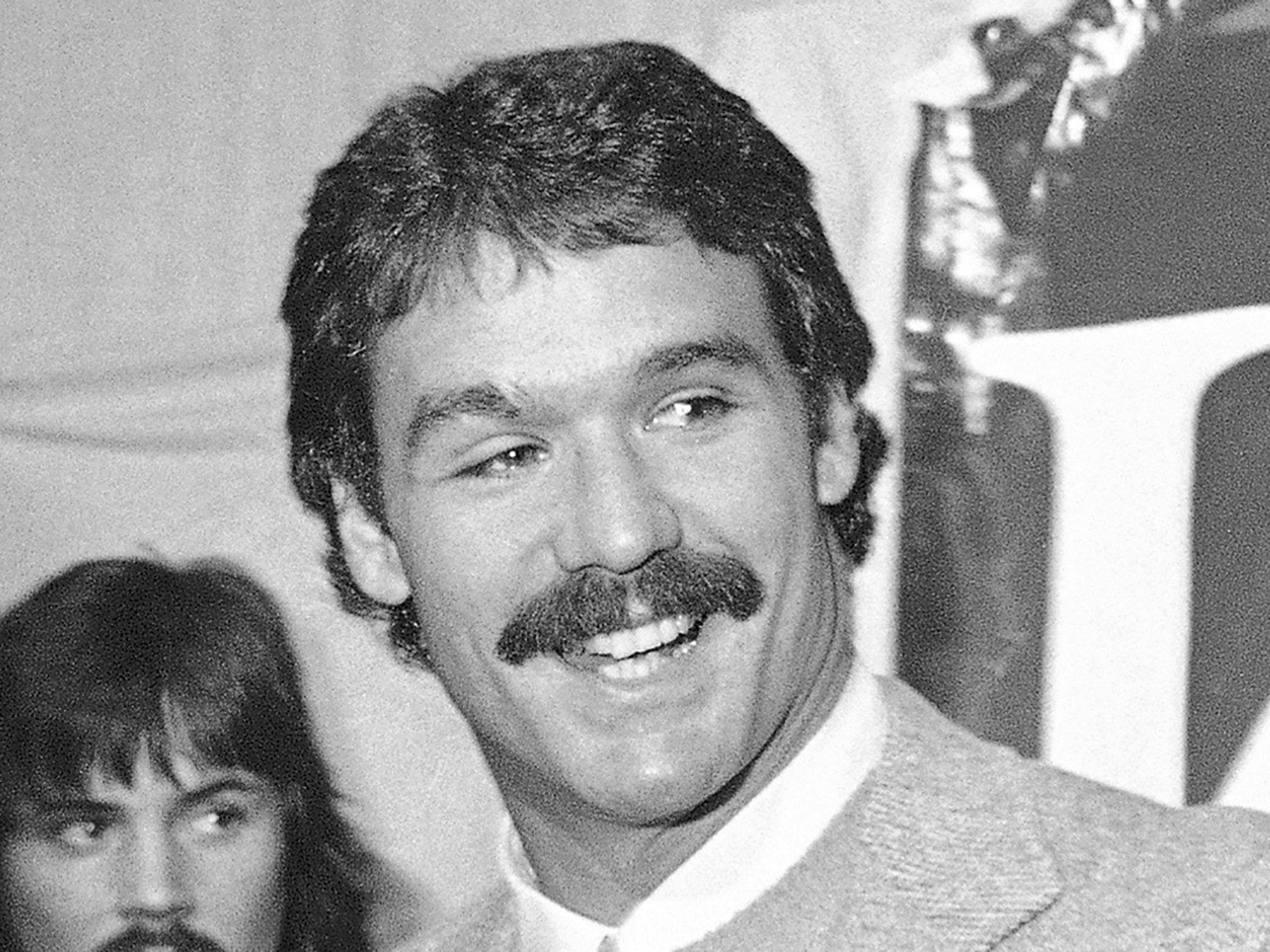 Russ Francis lächelt bei einer Pressekonferenz.