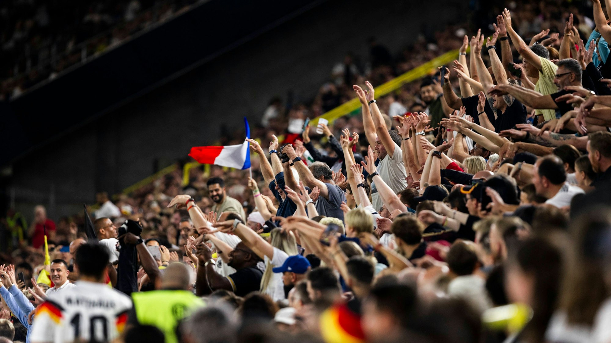 Die Fans machen eine La-Ola-Welle im Stadion.