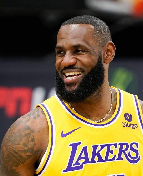 LeBron James grinst beim NBA-Medientag. Er trägt ein gelbes Lakers-Trikot.