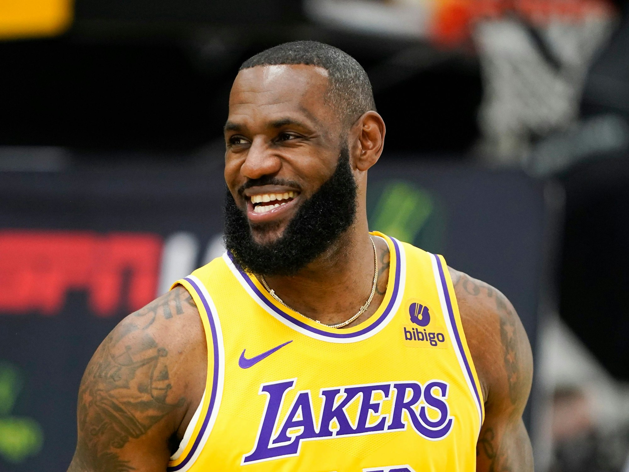 LeBron James grinst beim NBA-Medientag. Er trägt ein gelbes Lakers-Trikot.