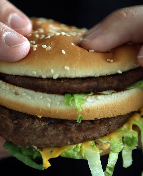 Ein Mann beißt in einen Big Mac von McDonald's.