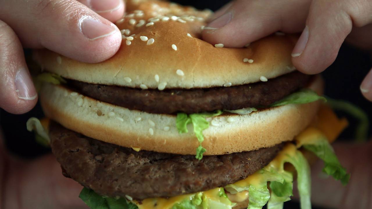 Ein Mann beißt in einen Big Mac von McDonald's.