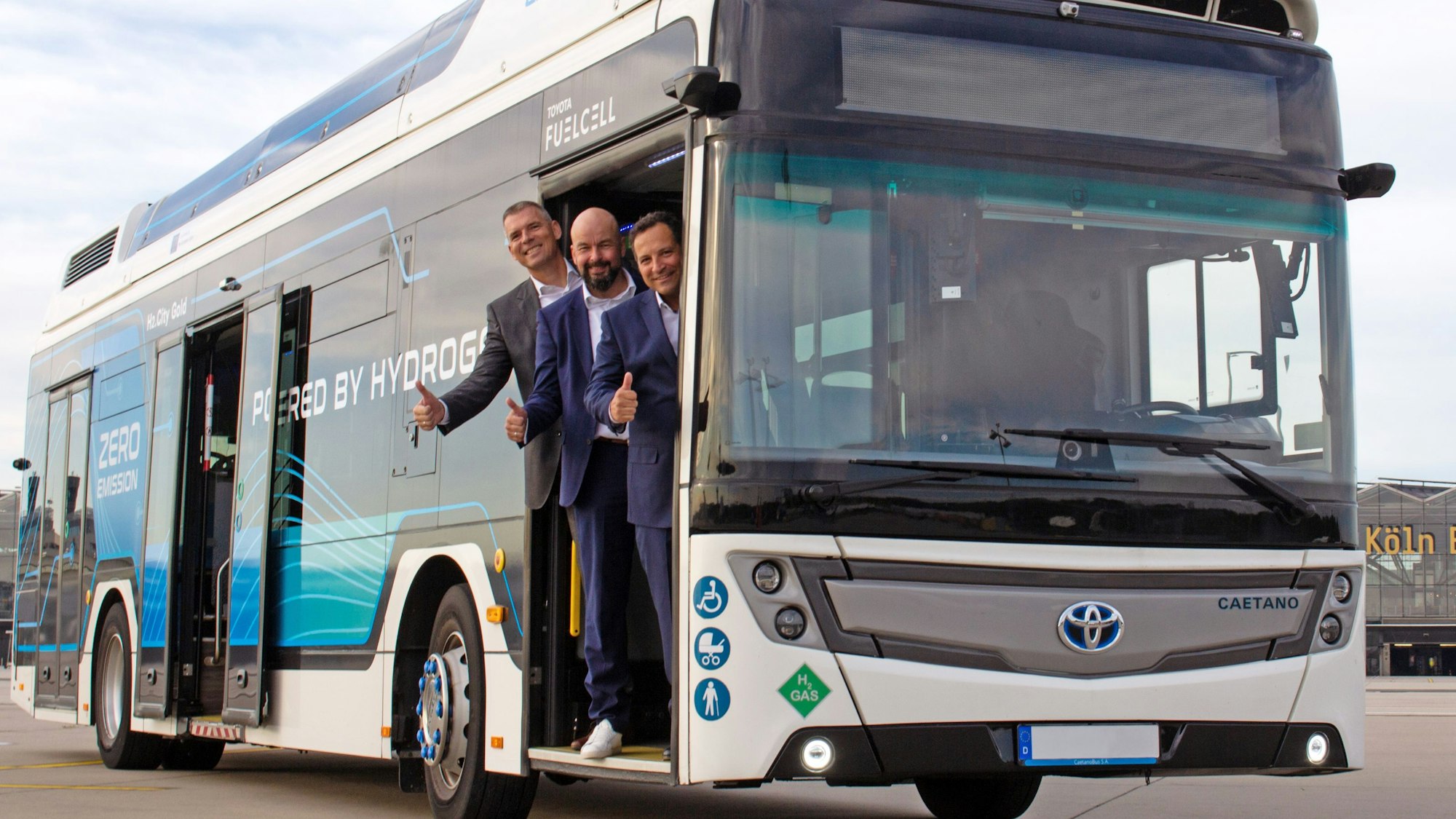 Drei Männer stehen in der Tür eines Busses.