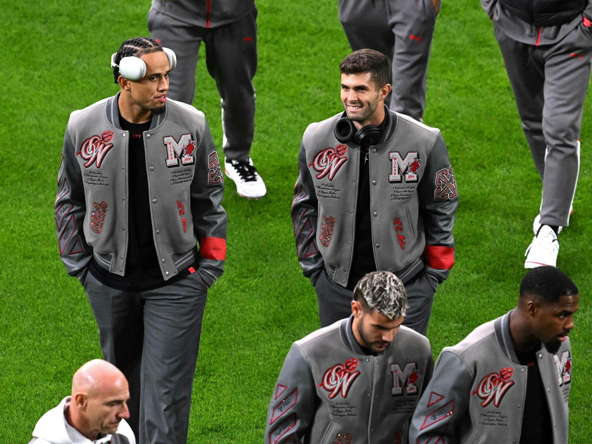 Die Milan-Profis inspizieren vor dem Spiel in Dortmund in College-Jacken den Rasen.