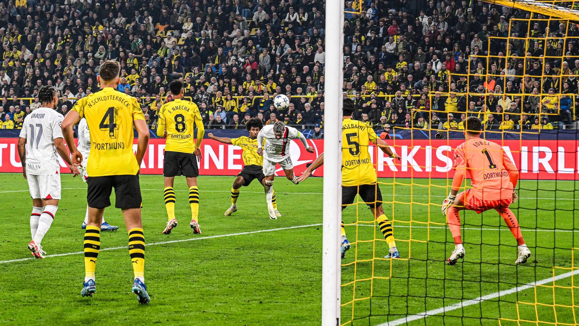 Theo Hernández köpft für Milan gegen den BVB aufs Tor. Karim Adeyemi kommt zu spät.