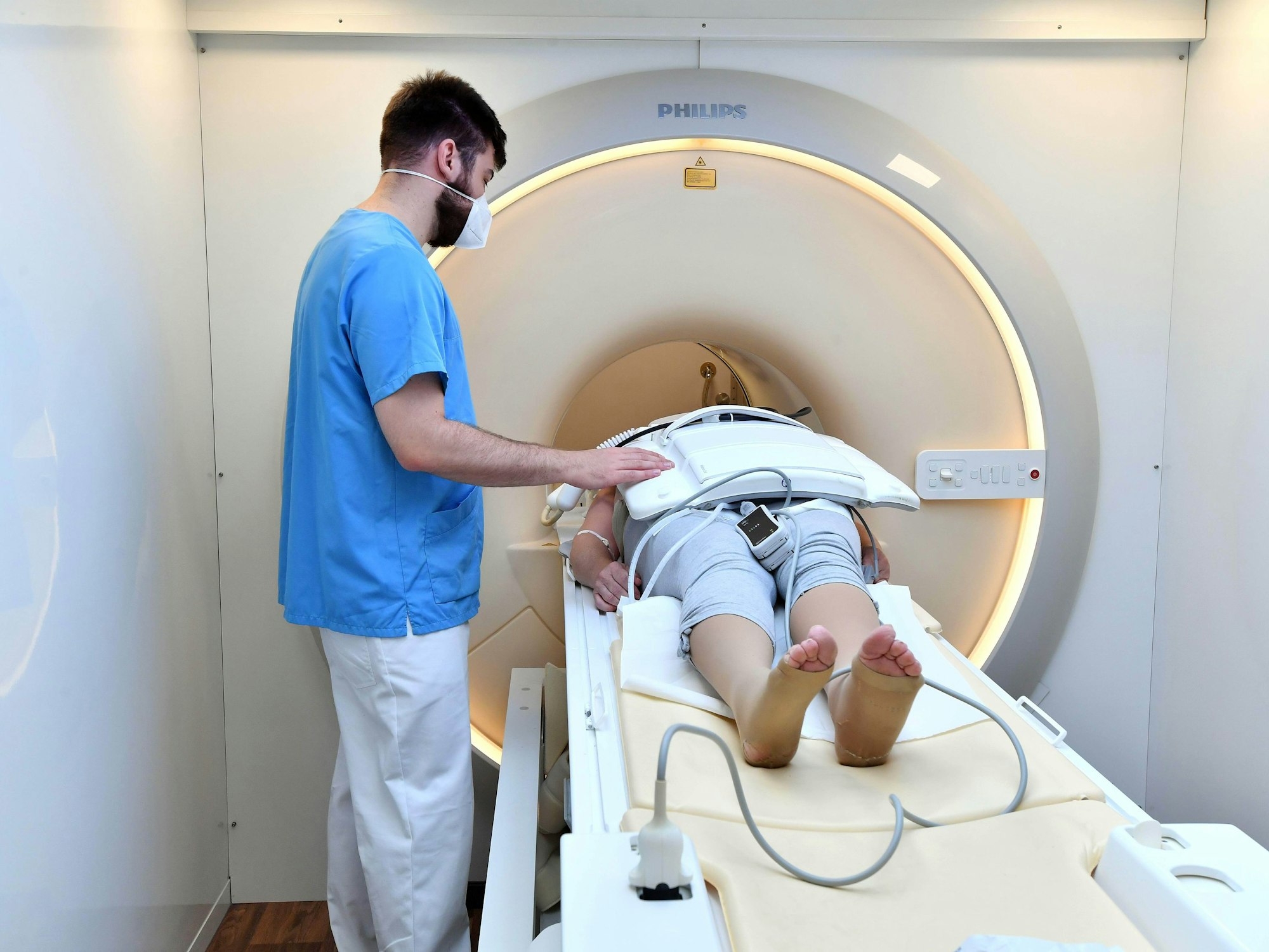 Ein Mitarbeiter untersucht eine Frau und macht eine MRT-Untersuchung, hier im Juli 2022 in Rostock.