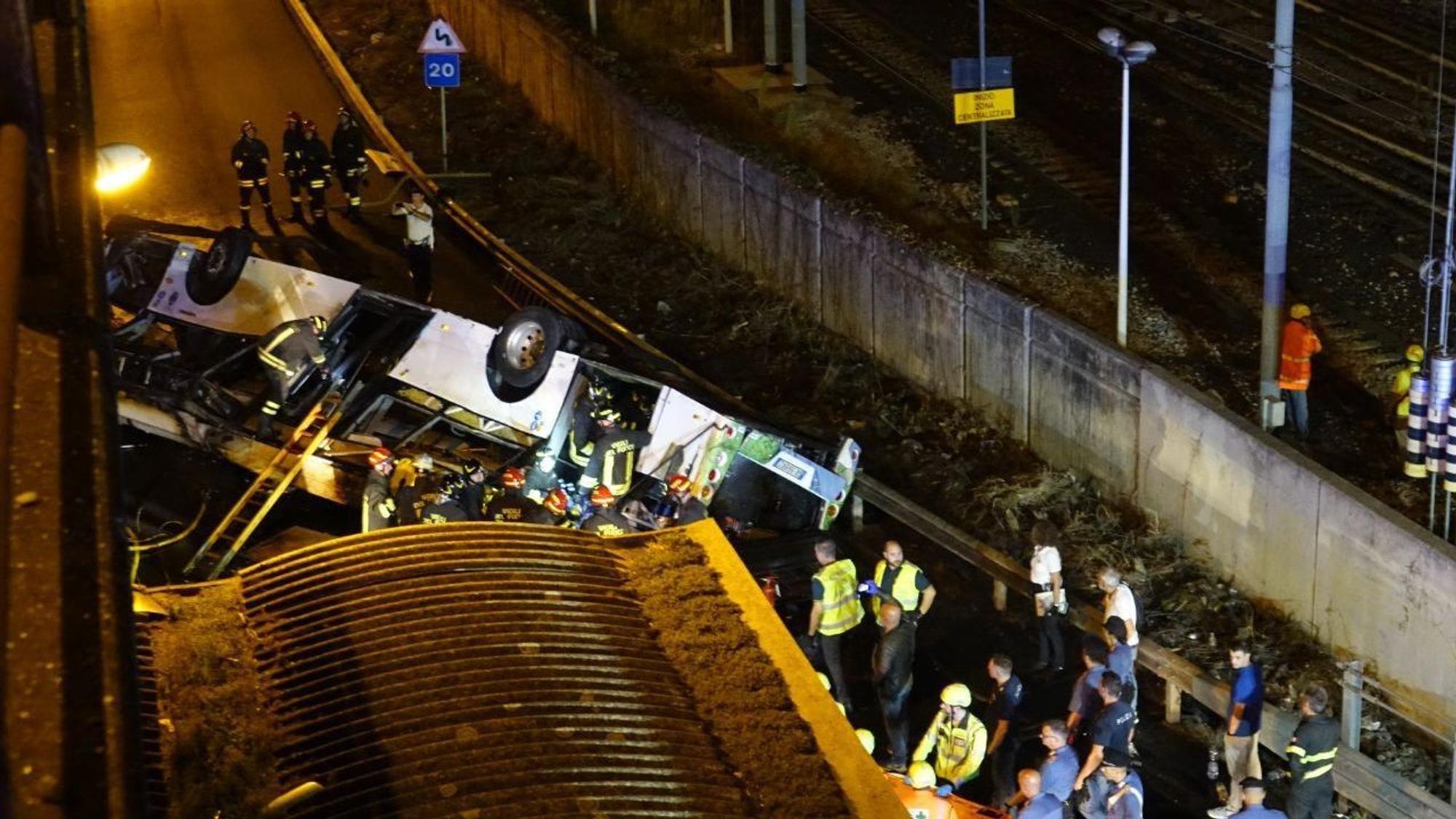 Ein Bus liegt unterhalb einer Brücke, zahlreiche Rettungskräfte wuseln herum.
