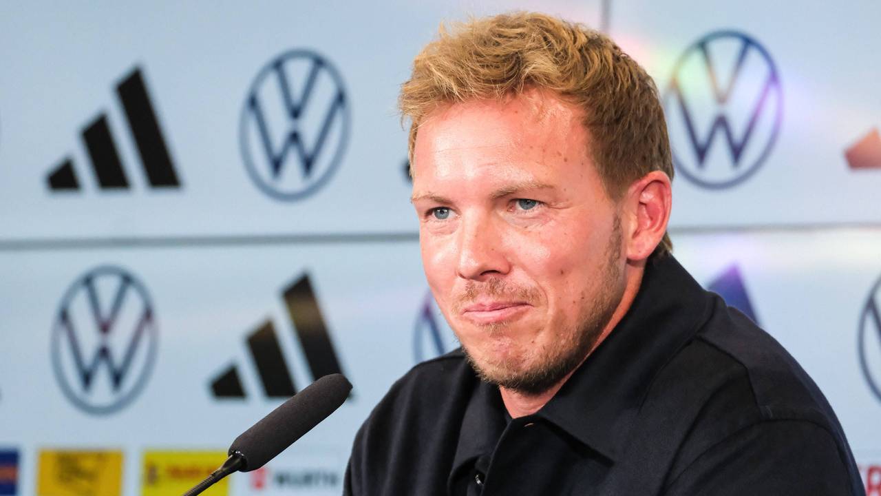 Julian Nagelsmann sitzt auf einer Pressekonferenz vor einem Mikrofon.