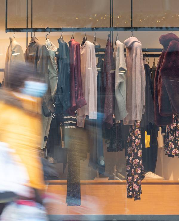 Eine Frau mit Maske geht im Dorotheen Quartier an einem Kleidungsgeschäft vorbei, hier im Dezember 2020.