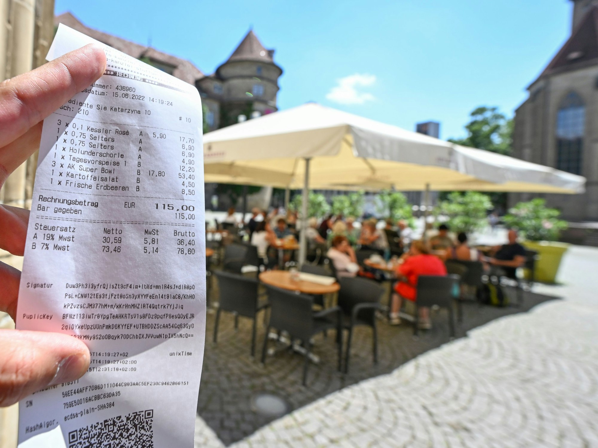 Eine Person hält in einem Restaurant in Stuttgart eine Rechnung für Getränke und Speisen in der Hand, hier im Juni 2022.